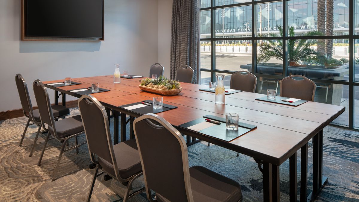 A modern Las Vegas Marriott meeting room with a conference table, ergonomic chairs, and floor-to-ceiling windows